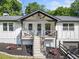 Inviting front porch with rocking chairs on this charming white home with black trim and a 2-car garage at 369 Arnold Mill Rd, Woodstock, GA 30188