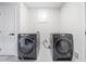 Convenient laundry room with two front-load washing machines and a white door at 369 Arnold Mill Rd, Woodstock, GA 30188
