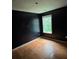Dark bedroom featuring wood floors and a small window at 4341 Savannah Ln, Atlanta, GA 30349