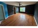 Spacious living room featuring hardwood floors, black walls and a ceiling fan at 4341 Savannah Ln, Atlanta, GA 30349