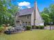 Home's backyard with a stone fire pit, patio seating, and lush landscaping at 4592 Planters Hill Dr, Powder Springs, GA 30127