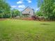 Expansive, green backyard with mature trees and home with covered porch at 4592 Planters Hill Dr, Powder Springs, GA 30127