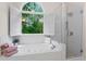 This bathroom features a large tub under a window with a glass-enclosed shower at 4592 Planters Hill Dr, Powder Springs, GA 30127