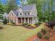 Charming two-story home with brick and siding, a covered porch, and beautifully landscaped front yard at 4592 Planters Hill Dr, Powder Springs, GA 30127