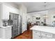 View of kitchen with stainless fridge showing view to living room with fireplace at 4592 Planters Hill Dr, Powder Springs, GA 30127