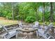 Backyard stone patio with built-in fire pit surrounded by Adirondack chairs at 4592 Planters Hill Dr, Powder Springs, GA 30127