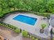 Aerial shot of a pristine backyard pool with surrounding landscaping and privacy fence for luxurious outdoor living at 4592 Planters Hill Dr, Powder Springs, GA 30127