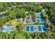 Aerial view of the community's amenities, including tennis courts, a swimming pool, and a clubhouse, surrounded by lush greenery at 5620 Preserve Cir, Johns Creek, GA 30005