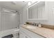 Bright bathroom with granite countertop, sliding shower door, and white cabinets at 5620 Preserve Cir, Johns Creek, GA 30005
