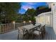 Outdoor dining on the deck features wood furnishings and string lights at dusk at 5620 Preserve Cir, Johns Creek, GA 30005