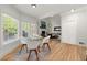 Sunlit dining area featuring a modern table, large windows, and an open view to the living room at 5620 Preserve Cir, Johns Creek, GA 30005