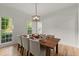 Dining room with hardwood floors, modern lighting, and large windows at 5620 Preserve Cir, Johns Creek, GA 30005