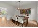 Charming dining room featuring hardwood floors, modern lighting, seating for six and colorful contemporary art at 5620 Preserve Cir, Johns Creek, GA 30005