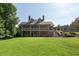 Exterior view of a two-story home with a stone foundation, a large lawn, and an inviting porch at 5620 Preserve Cir, Johns Creek, GA 30005