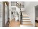 Bright foyer boasts hardwood floors, staircase with black metal railings, and an open floor plan to the second level at 5620 Preserve Cir, Johns Creek, GA 30005