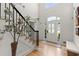 Welcoming foyer features hardwood floors, an elegant staircase, and a clear view of the front door and transom window at 5620 Preserve Cir, Johns Creek, GA 30005