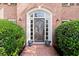 Elegant front door with decorative glass, surrounded by lush greenery and charming flower planters at 5620 Preserve Cir, Johns Creek, GA 30005