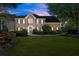 Beautiful brick home at twilight with manicured lawn, mature trees, and inviting front entrance at 5620 Preserve Cir, Johns Creek, GA 30005