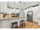 Well-lit kitchen with granite countertops, stainless steel appliances, white cabinets and hardwood floors at 5620 Preserve Cir, Johns Creek, GA 30005
