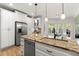 Kitchen featuring white cabinets, stainless steel appliances, a granite sink, and a breakfast area with natural light at 5620 Preserve Cir, Johns Creek, GA 30005
