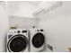 Modern laundry room featuring front-load washer and dryer with wire shelving at 5620 Preserve Cir, Johns Creek, GA 30005