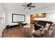 Spacious living room with a media screen, ceiling fan and a built-in bar area with wooden cabinets at 5620 Preserve Cir, Johns Creek, GA 30005