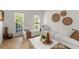 Bright living room with hardwood floors, comfortable white seating, and decorative wall art with natural light from windows at 5620 Preserve Cir, Johns Creek, GA 30005