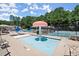Community splash pad with fun water features, surrounded by lounge chairs and a tennis court at 5620 Preserve Cir, Johns Creek, GA 30005