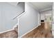 Hallway with stairs features wood-look flooring and a view into the main living area with fireplace at 5654 Lawley Dr, Alpharetta, GA 30022
