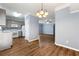 Open concept living space with wood floors connecting the kitchen, dining, and living areas at 5654 Lawley Dr, Alpharetta, GA 30022
