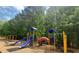 Community playground with slides, swings, and climbing structures surrounded by mature trees at 5654 Lawley Dr, Alpharetta, GA 30022