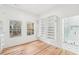 Bright walk-in closet featuring custom shelving, hardwood floors, and view to a tiled bathroom with glass enclosed shower at 2396 Sunset Ne Dr, Atlanta, GA 30345