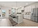 Well-lit kitchen features stainless steel appliances, white cabinets, an island with seating and direct patio access at 407 Nix Ln, Lawrenceville, GA 30046