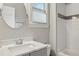 Well-lit bathroom featuring a round mirror, subway tile shower, and a single vanity with Carrara marble countertop at 519 2Nd Ave, Decatur, GA 30030