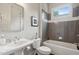 Neutral bathroom featuring tub with gray tiled surround, sink with silver faucet and modern mirror at 519 2Nd Ave, Decatur, GA 30030