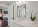 Bright bathroom featuring a marble countertop with a square framed mirror, a white orchid, and a glimpse of the bedroom at 519 2Nd Ave, Decatur, GA 30030