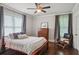 Cozy bedroom featuring hardwood floors, a ceiling fan, neutral tones, and ample natural light from the large windows at 519 2Nd Ave, Decatur, GA 30030
