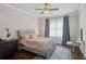 Comfortable bedroom with a cozy bed, a ceiling fan, and dark wood floors with a view of a desk and a large window at 519 2Nd Ave, Decatur, GA 30030