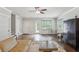 Open concept living room with hardwood floors, neutral tones, multiple doors and windows, and an antique-inspired armoire at 519 2Nd Ave, Decatur, GA 30030