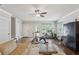 Multi-purpose living area featuring exercise equipment, neutral tones, hardwood floors, a tan sectional, and a vintage-inspired armoire at 519 2Nd Ave, Decatur, GA 30030