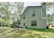 Backyard with a patio, exterior door, mature trees, and ample green space at 655 Barrington Way, Roswell, GA 30076