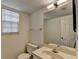 Bathroom featuring a toilet, sink, mirror and window with natural light at 655 Barrington Way, Roswell, GA 30076