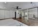 Bright bedroom featuring wood floors, ceiling fan, and closet doors with mirrors at 655 Barrington Way, Roswell, GA 30076