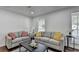 Cozy living room features two sofas, a coffee table, and bright natural light from the windows at 655 Barrington Way, Roswell, GA 30076