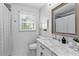 Bright bathroom with a marble countertop vanity, a window, and a shower with a curtain at 4257 Edgewater Nw Dr, Kennesaw, GA 30144