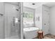 Modern bathroom boasting a glass-enclosed shower, freestanding tub, and sleek white subway tiles at 4257 Edgewater Nw Dr, Kennesaw, GA 30144