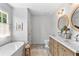 Elegant bathroom featuring a soaking tub, dual vanities with marble countertops, and neutral tile flooring at 4257 Edgewater Nw Dr, Kennesaw, GA 30144