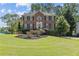 Charming brick home featuring a well-kept lawn, symmetrical design, and mature trees at 4257 Edgewater Nw Dr, Kennesaw, GA 30144