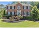 Beautiful brick home with manicured lawn, black shutters, and classic architectural details at 4257 Edgewater Nw Dr, Kennesaw, GA 30144