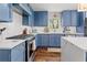 Modern kitchen with blue cabinets, white backsplash, stainless appliances and a gas cooktop at 4257 Edgewater Nw Dr, Kennesaw, GA 30144